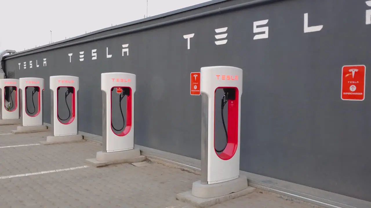 Tesla Electric Car Supercharger Charging Stations without people near a grey wall in the parking lot on the terrace of a mall in Romania close pan left day view