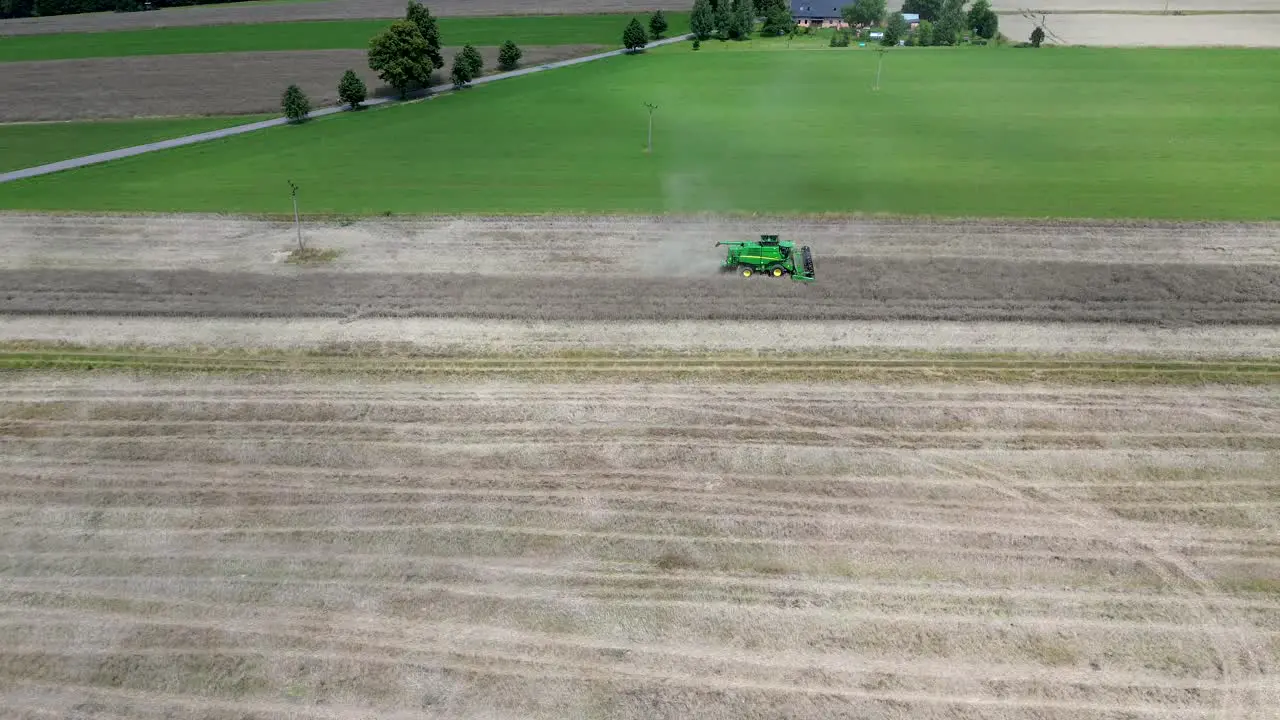 A view of efficient combined harvesting in action when the camera from the drone captures the harvester from the side while descending