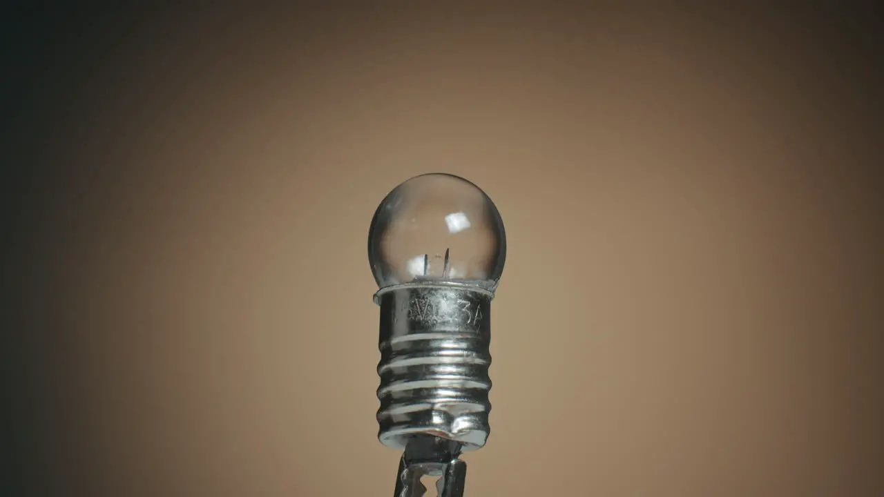 Close up of a Tungsten Filament Light Bulb and Macro Shot of Electronic Components on Turn Table