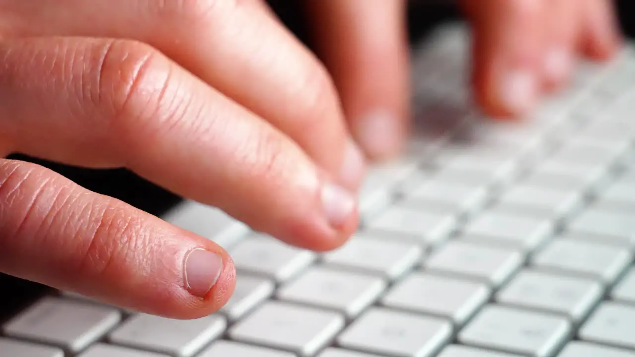 hands and fingers typing on keyboard on computer closeup shot