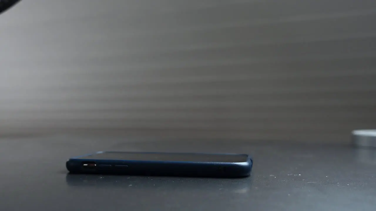 A young person puts his phone on the table to concentrate on his work and not be distracted