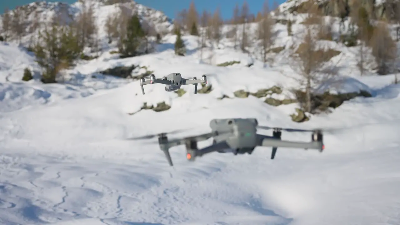 DJI Air 2S And Air 3 Hovering Above Snowy Landscape