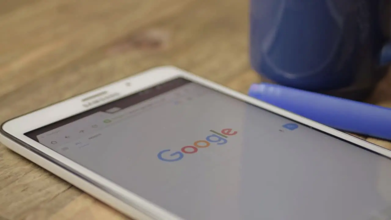 Google homepage and logo displayed on tablet with drink and pen