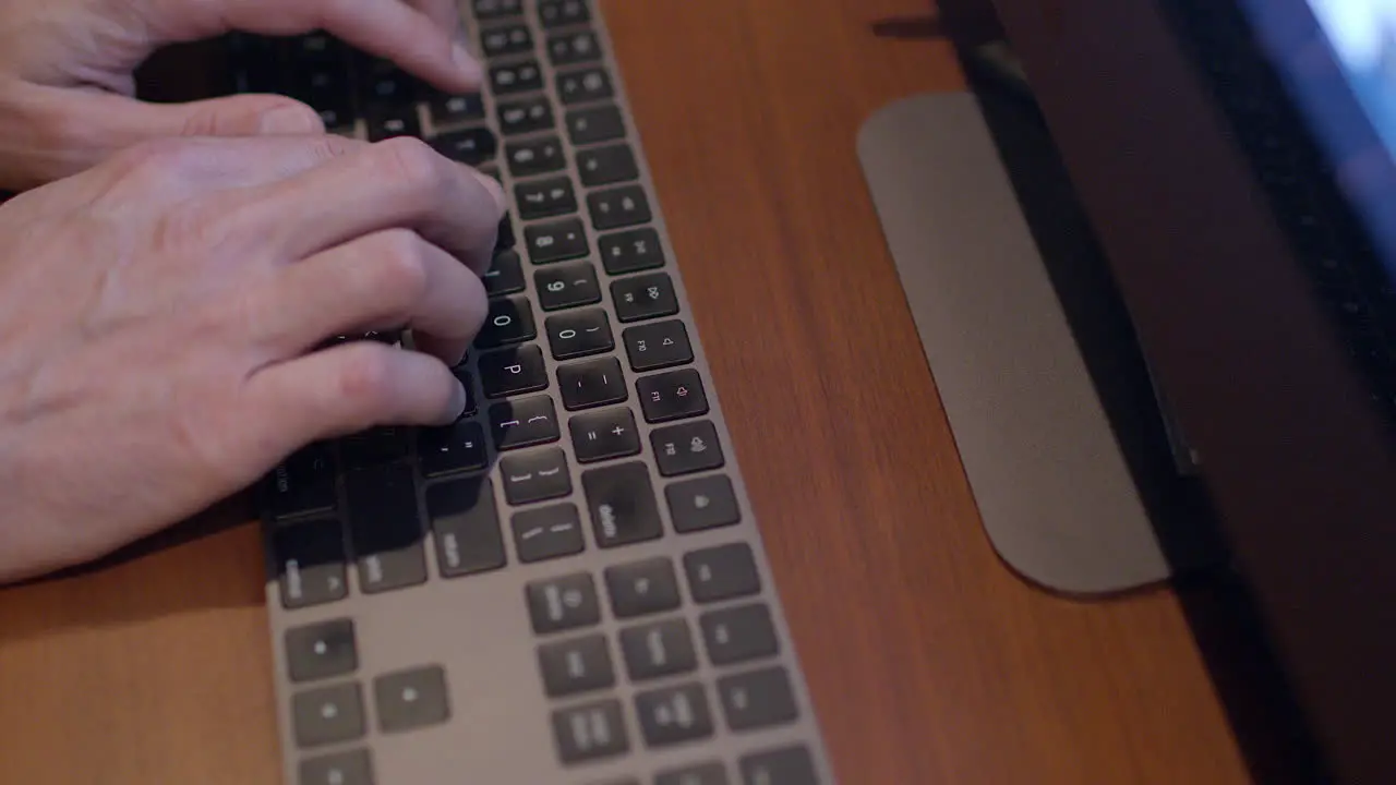 Closeup of a man's hands typing on a keyboard