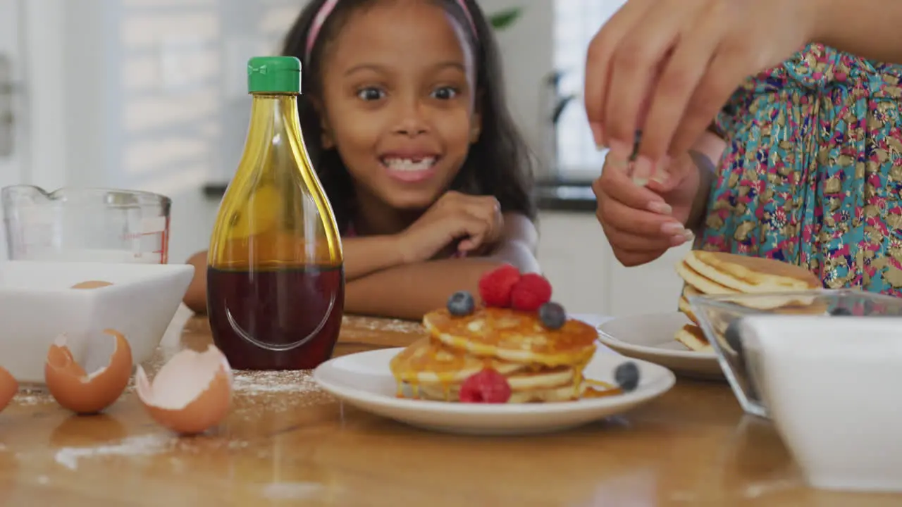 Video of african american mother and daughter cooking together in the kitchen