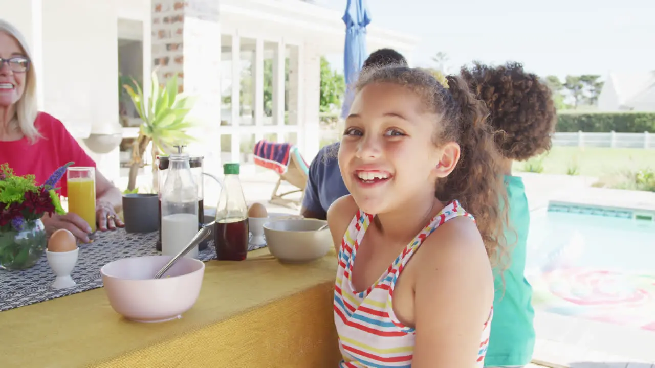 Video of biracial girl with diverse family spending time together and having dinner outside