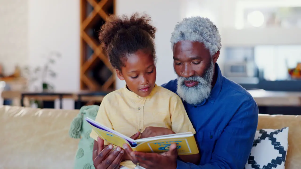 Grandfather child and reading books on sofa