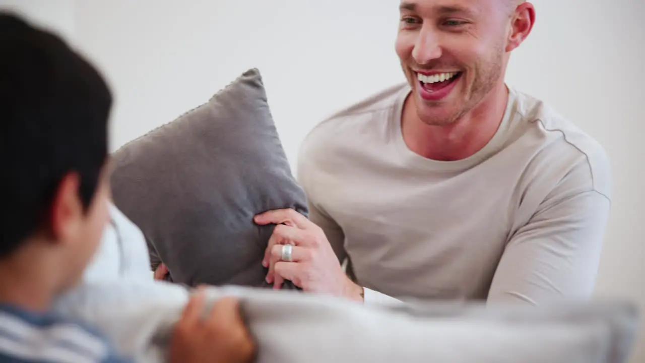 Happy pillow fight and father with child on bed