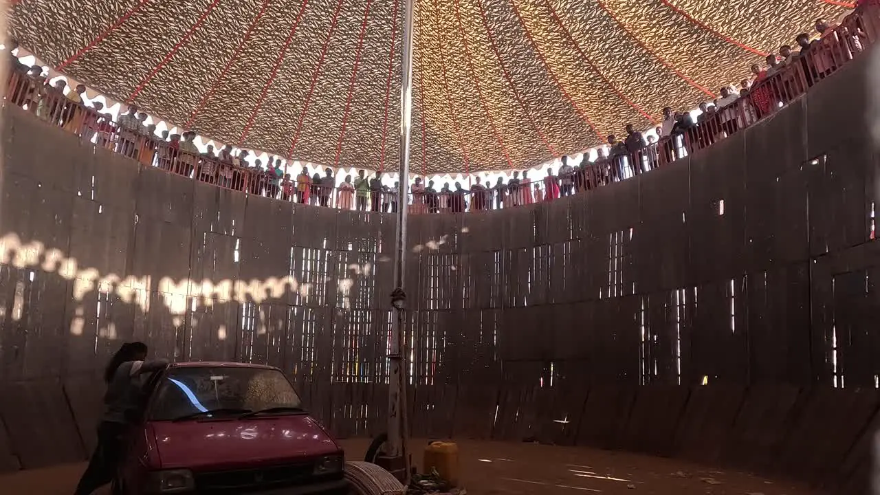 The well of death scene in which thousands of people watch the bike and car do it in the well of death the bike going round and round at full speed