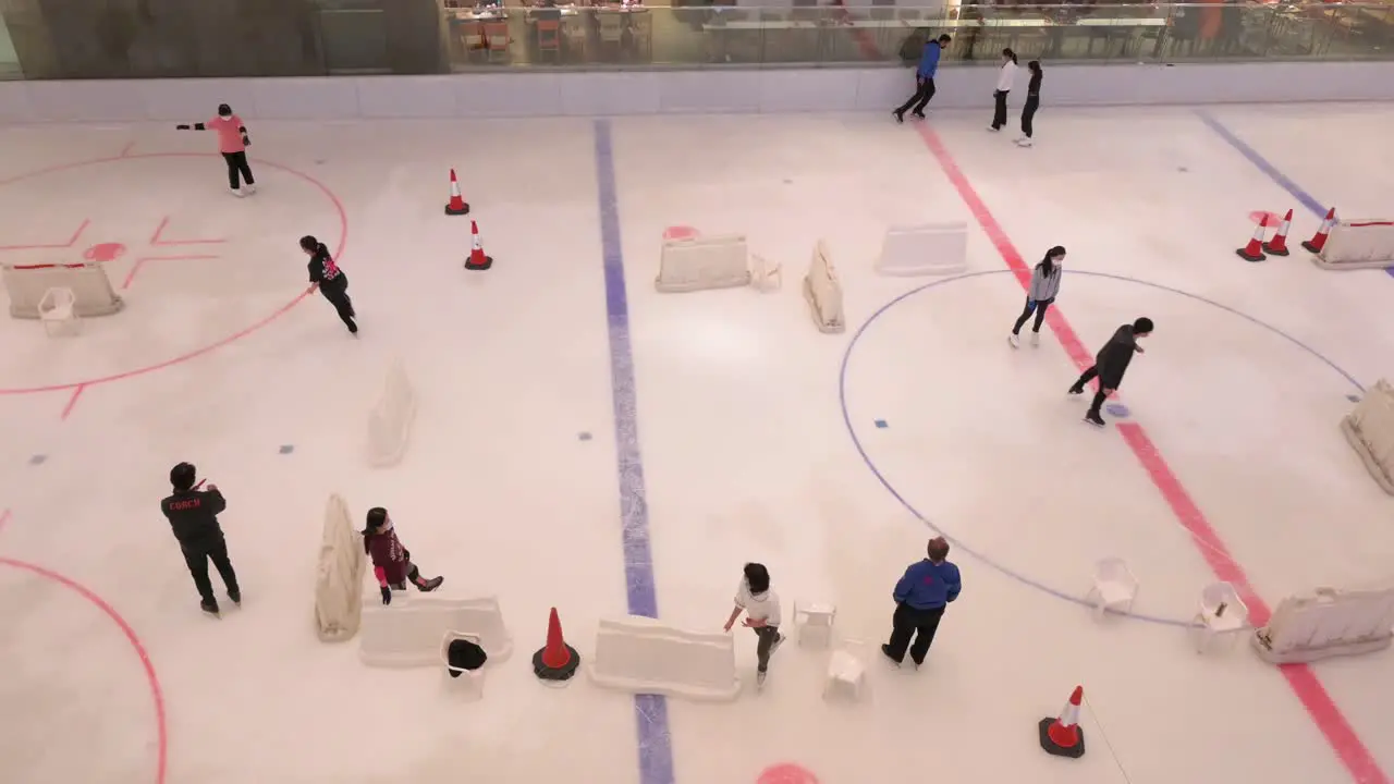 People of all ages are seen enjoying and learning indoor ice skating at a shopping mall in Hong Kong