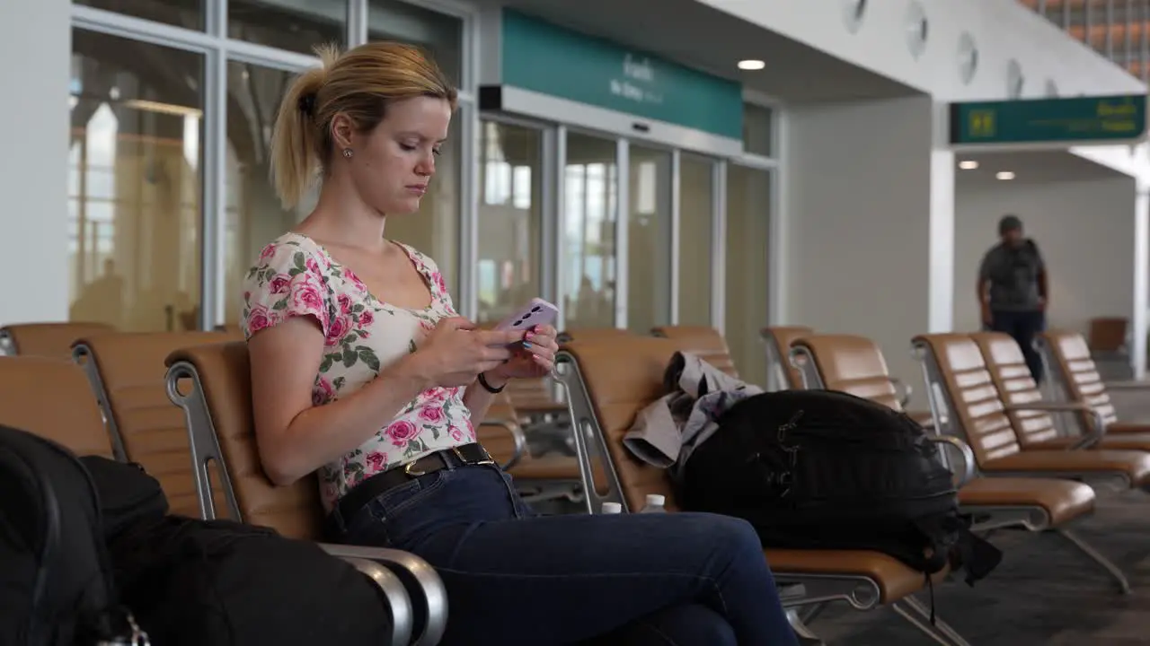 Young woman using her smartphone relaxing at the airport