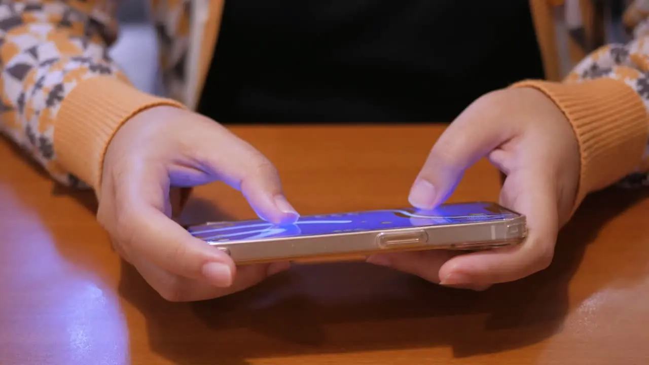 Detail of female hands playing with cell phone