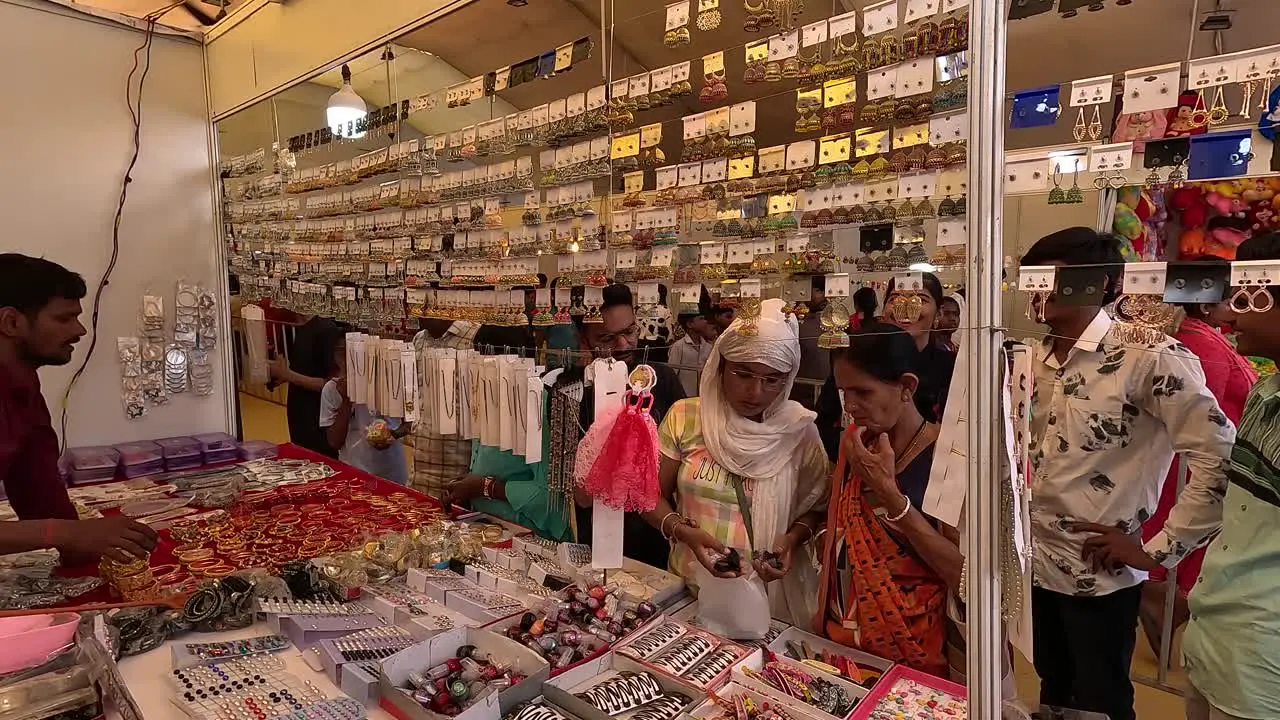 Young girls buying silver imitation jewelery with their parents