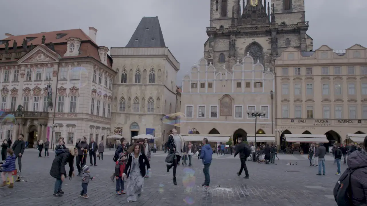 Prague's Old Town Square with soap bubbles flying over the heads of tourists and locals