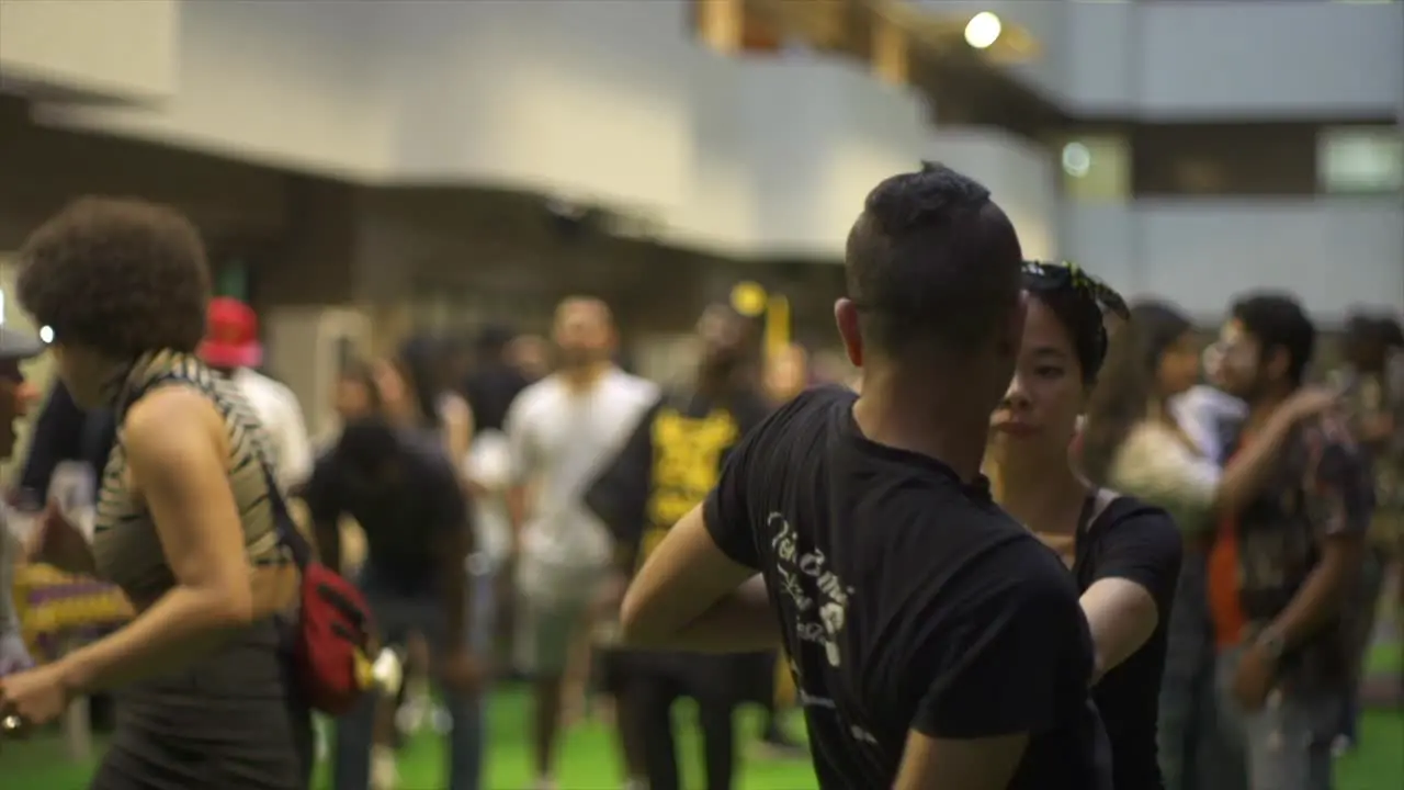 Asian woman and Indian man spin dancing to live music at ethnic cultural event filmed as medium close up slow motion shot in handheld style