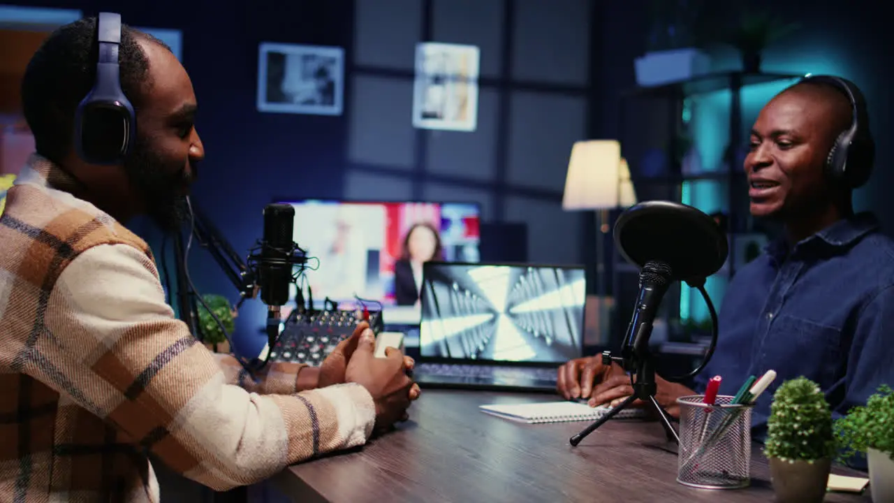 Cheerful man listening to guest live during broadcasting session for internet show