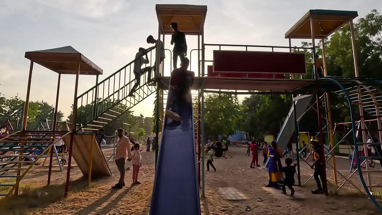 A lot of kids are sliding in the amusement park during the holidays and the kids are having fun