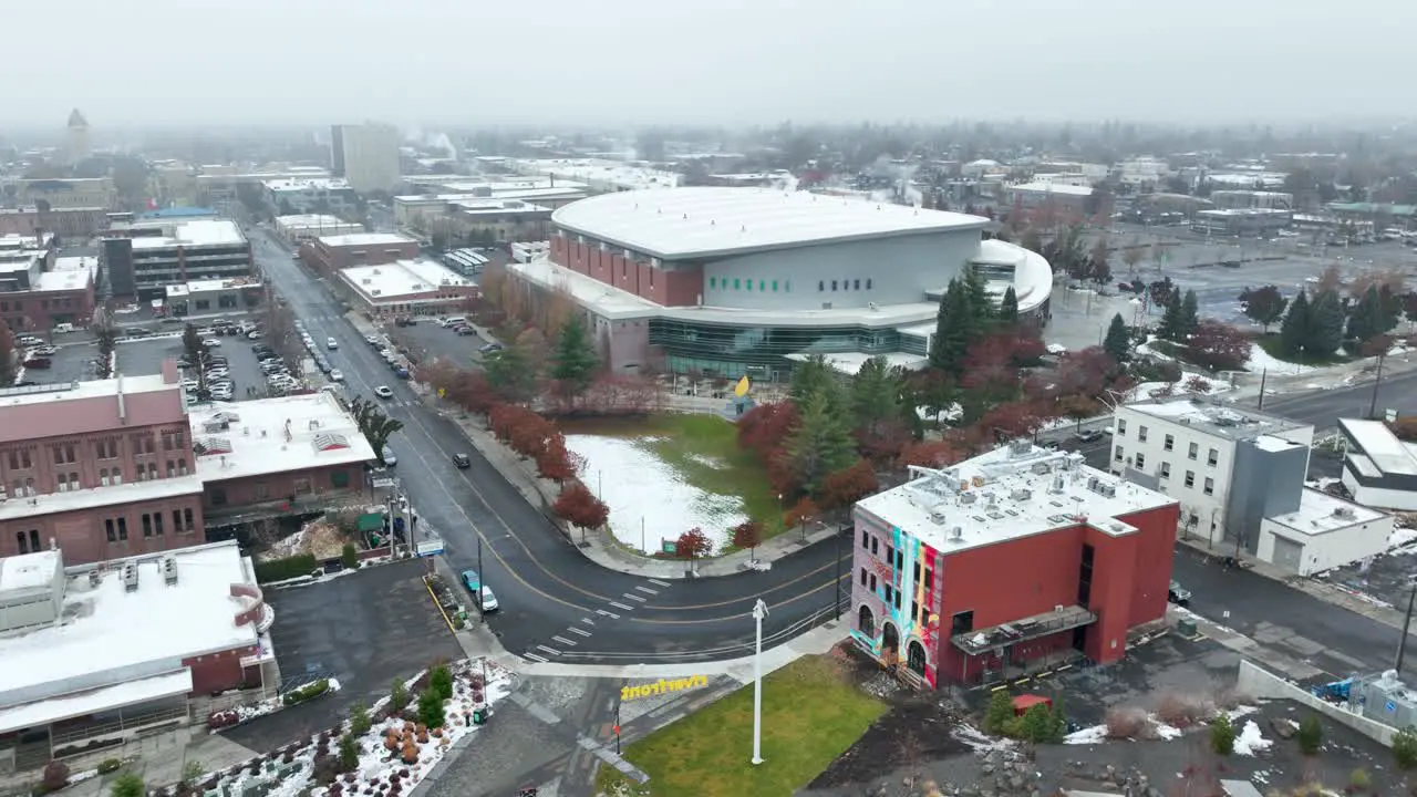 Wide orbiting aerial shot of the Spokane Arena with buildings surrounding it