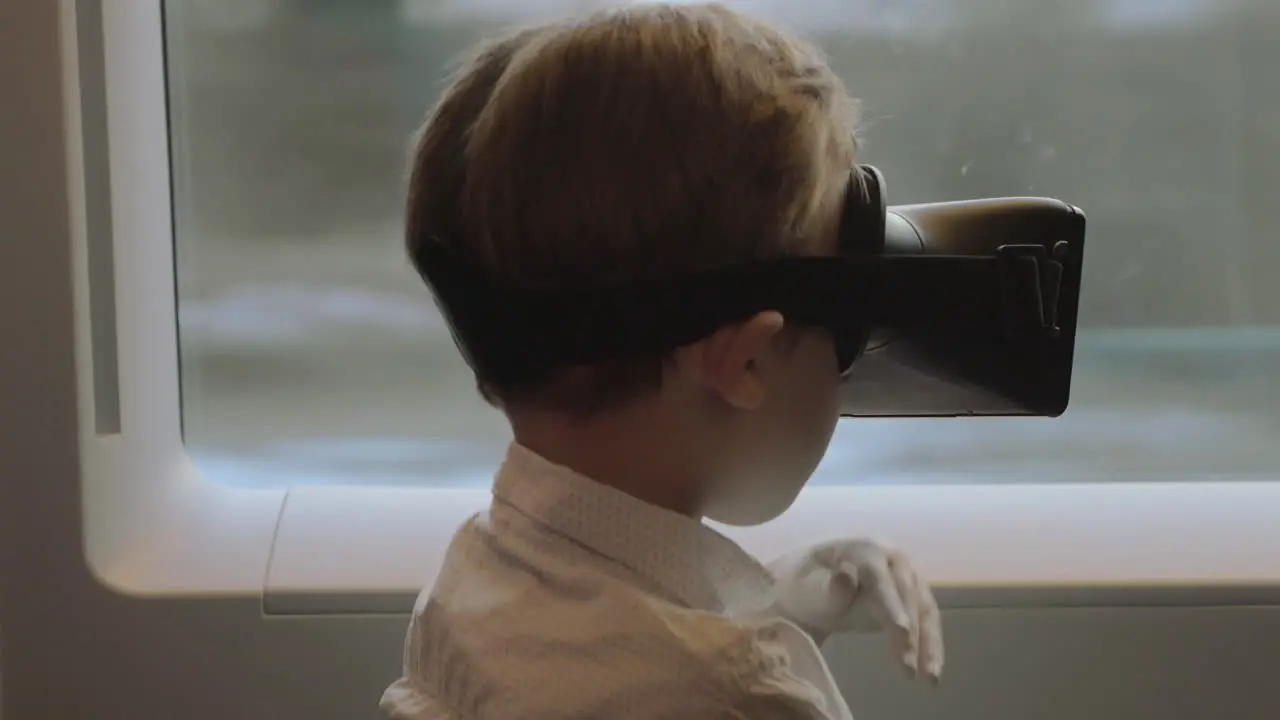 Child having fun in the train with VR glasses