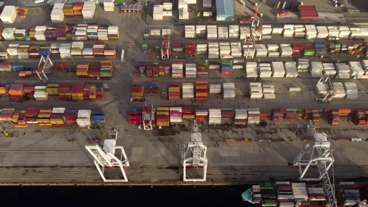 Port full of stacked shipping containers handled by cranes