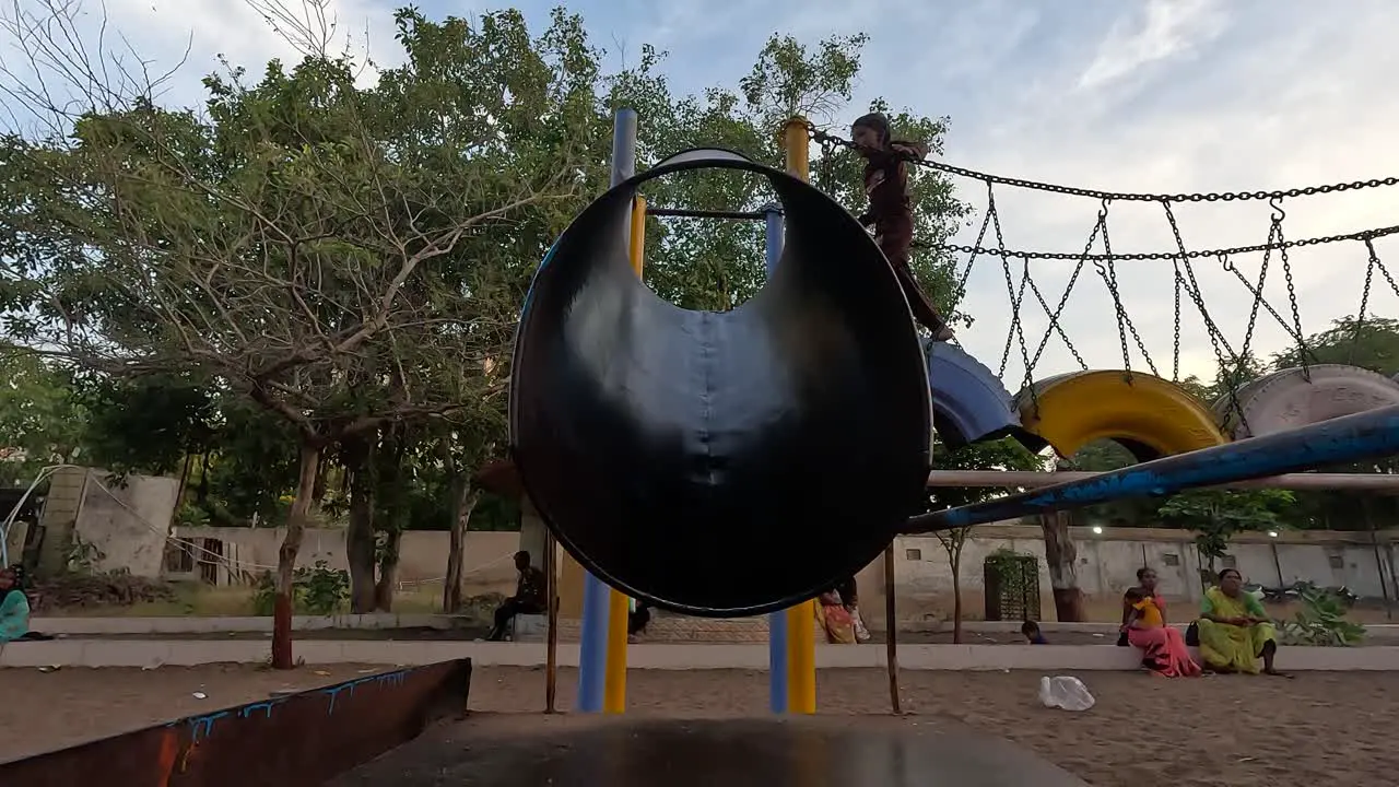 A small child is sledding in a public theme park on holiday