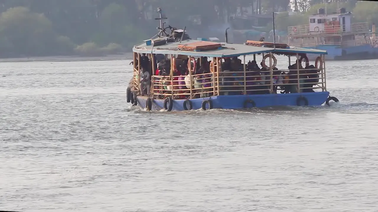 A Small Ferry boat full of passengers moving towards shore in middle of the bay video background in Full HD