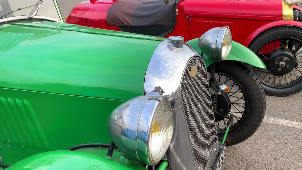 Three classic old antique racing cars vintage cars at a parking in England expensive exclusive collectible cars single seat 4K shot