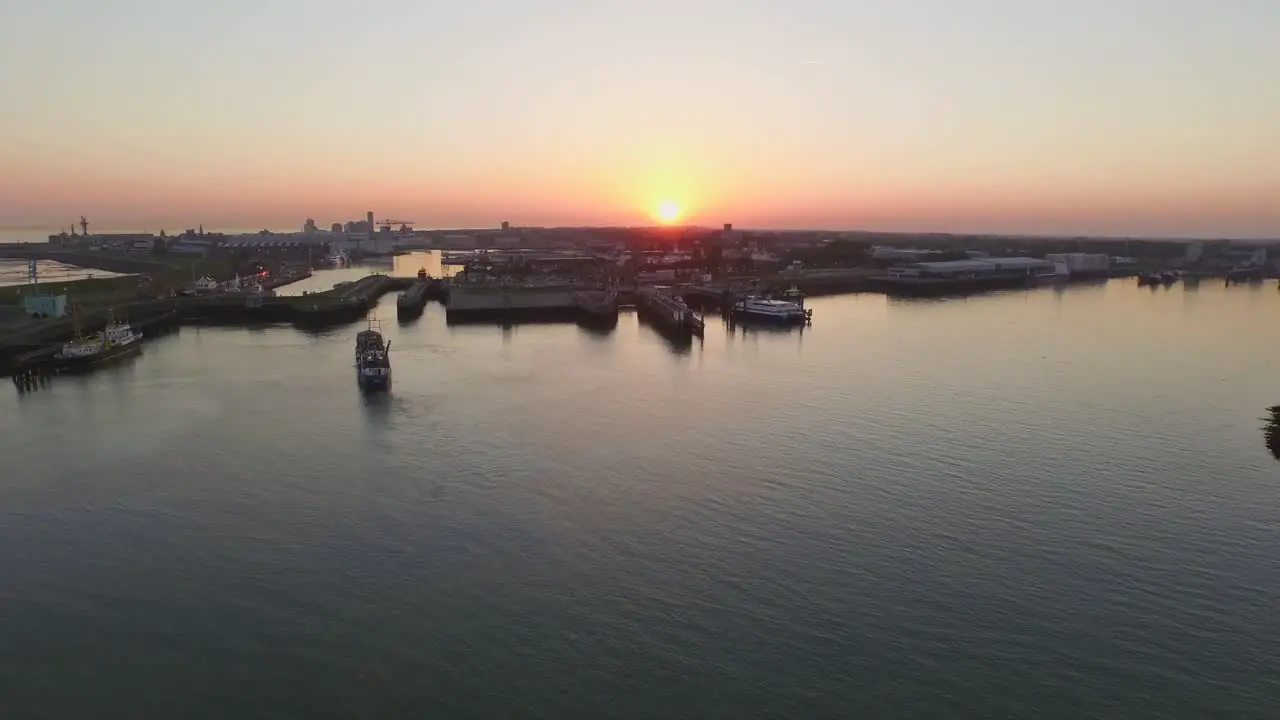 Aerial The smaller port of Vlissingen with cargo ships passing by during sunset