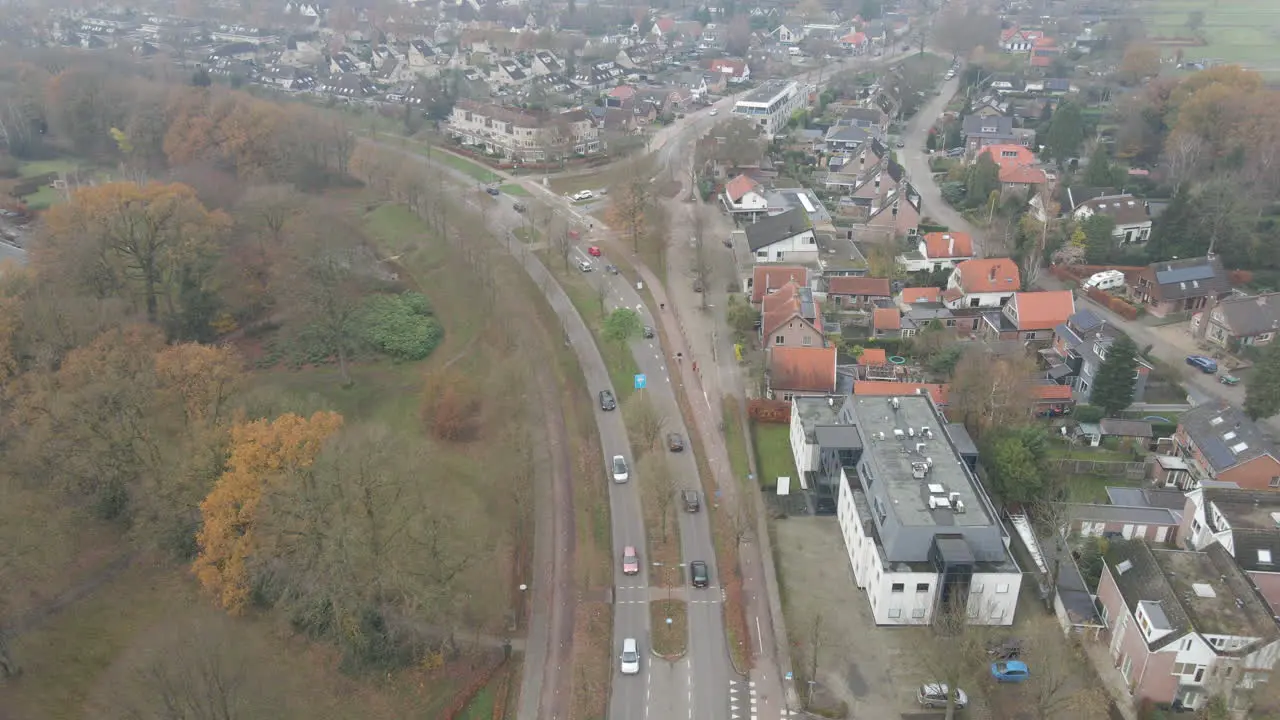 Aerial of traffic driving over busy road in small city