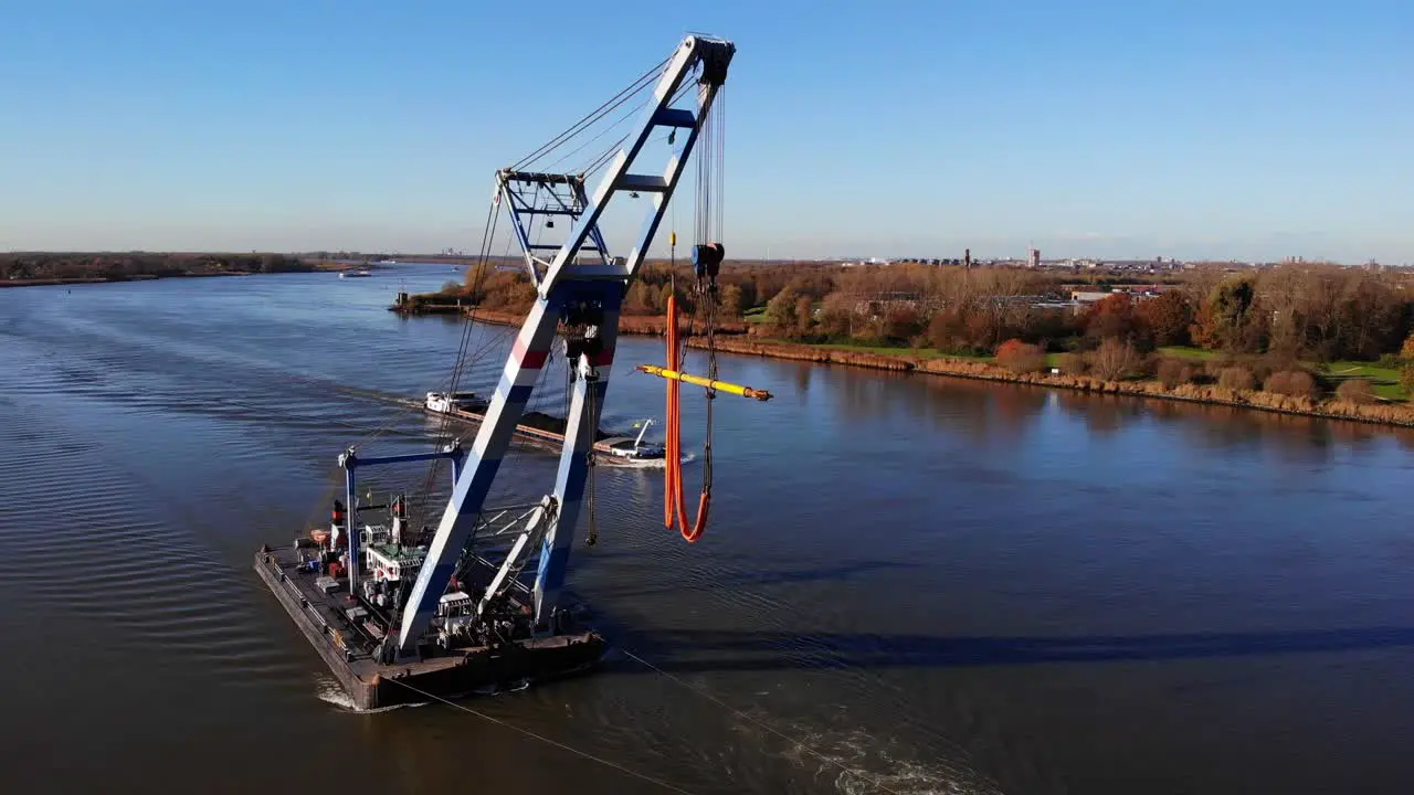 Tugboat and Floating Sheerleg Navigating The River With Vast Riverside Landscape In Barendrecht Netherlands