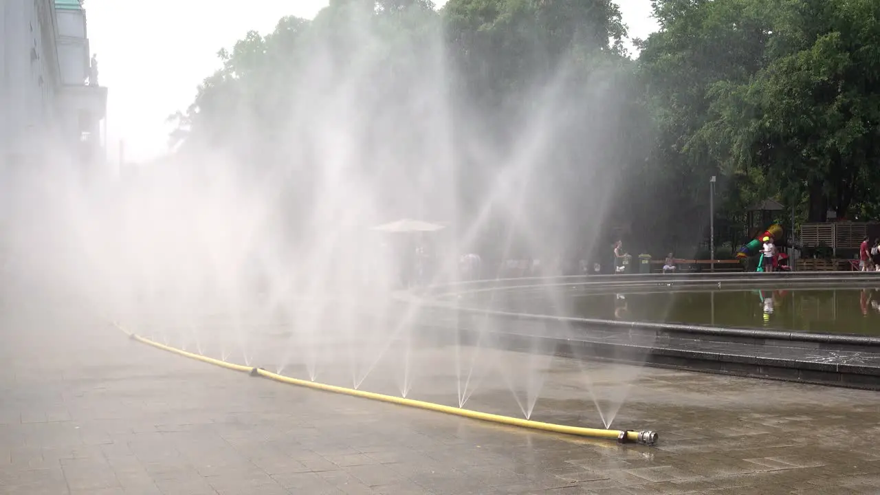 People enjoying refreshing water fountain during heatwave in Europe