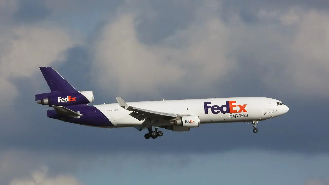 Tracking Shot FedEX MD-11F Cargo Freighter Approaching the Airport with Clouds in the Background