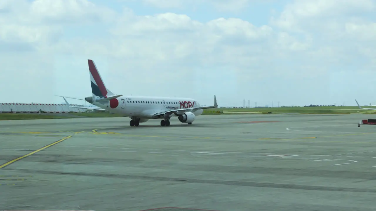 Wide shot of Air France HOP jet taxiing towards runway Charles de Gaulle airport