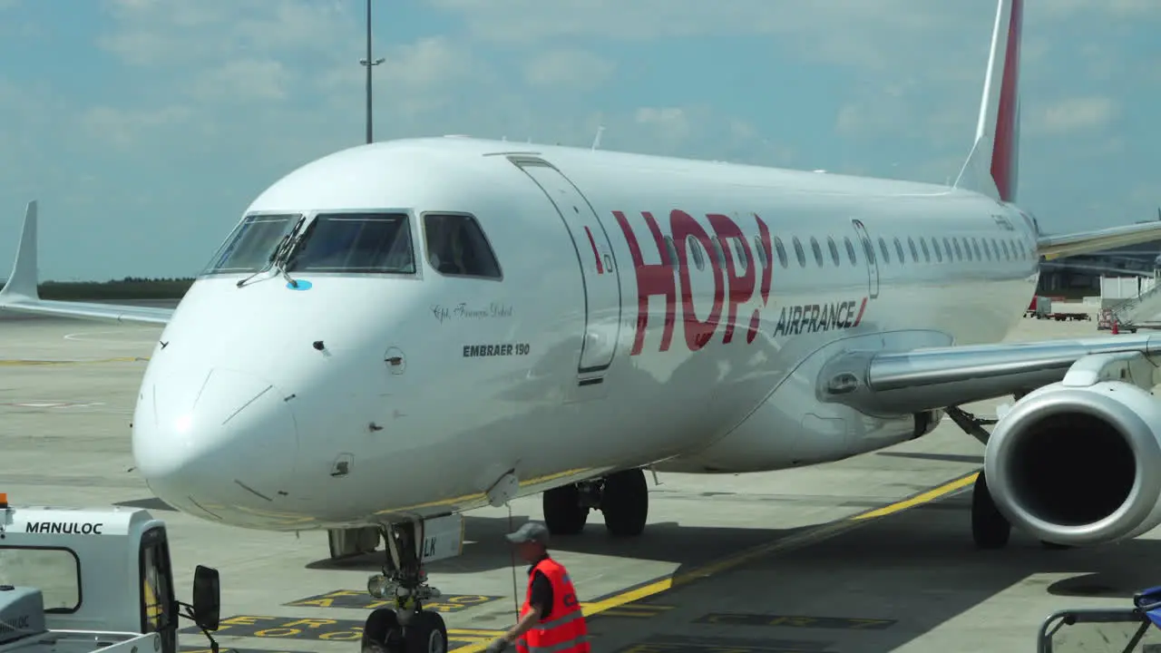 Embraer 190 Air France Hop jet parked at gate being prepared for pushback takeoff