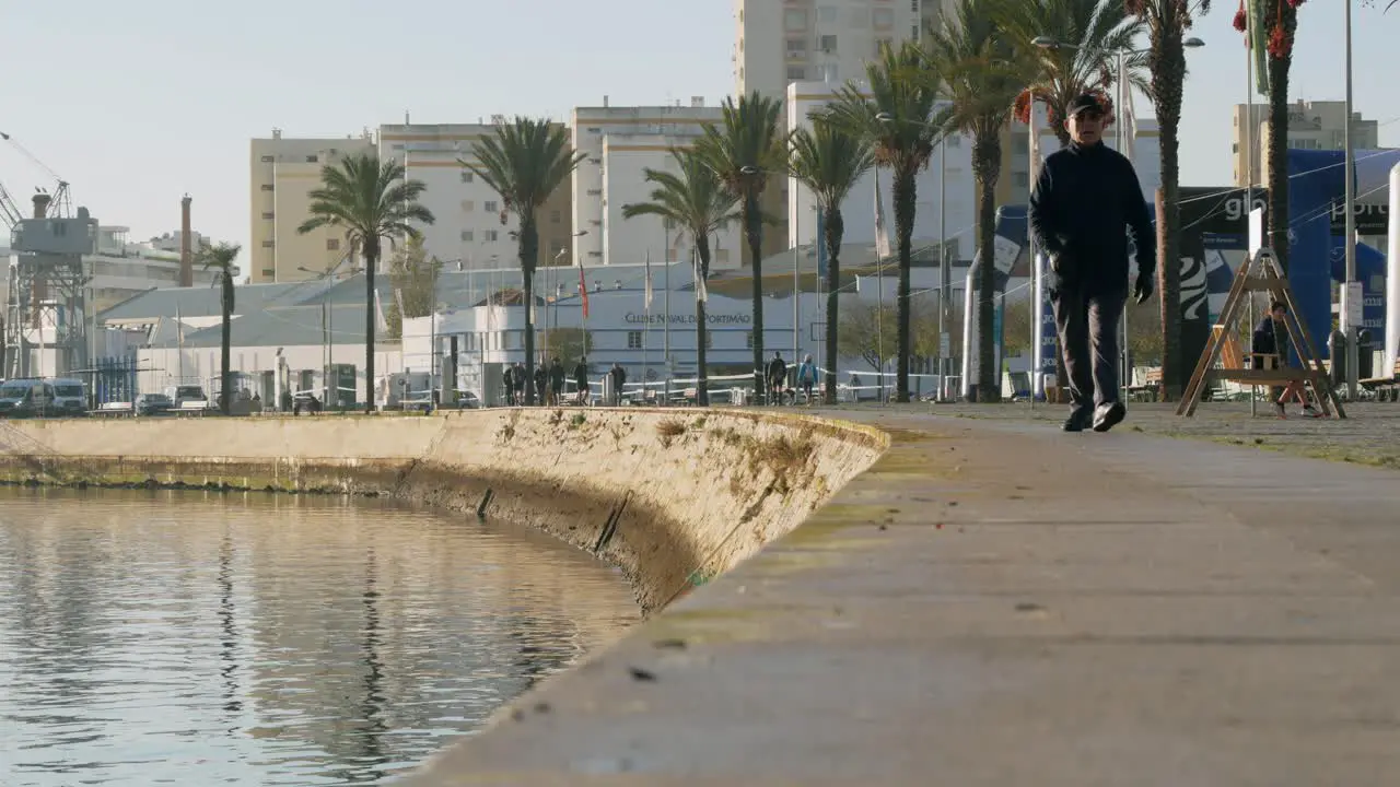 People walking by the river on a sunny morning promenade view Portimão Algarve