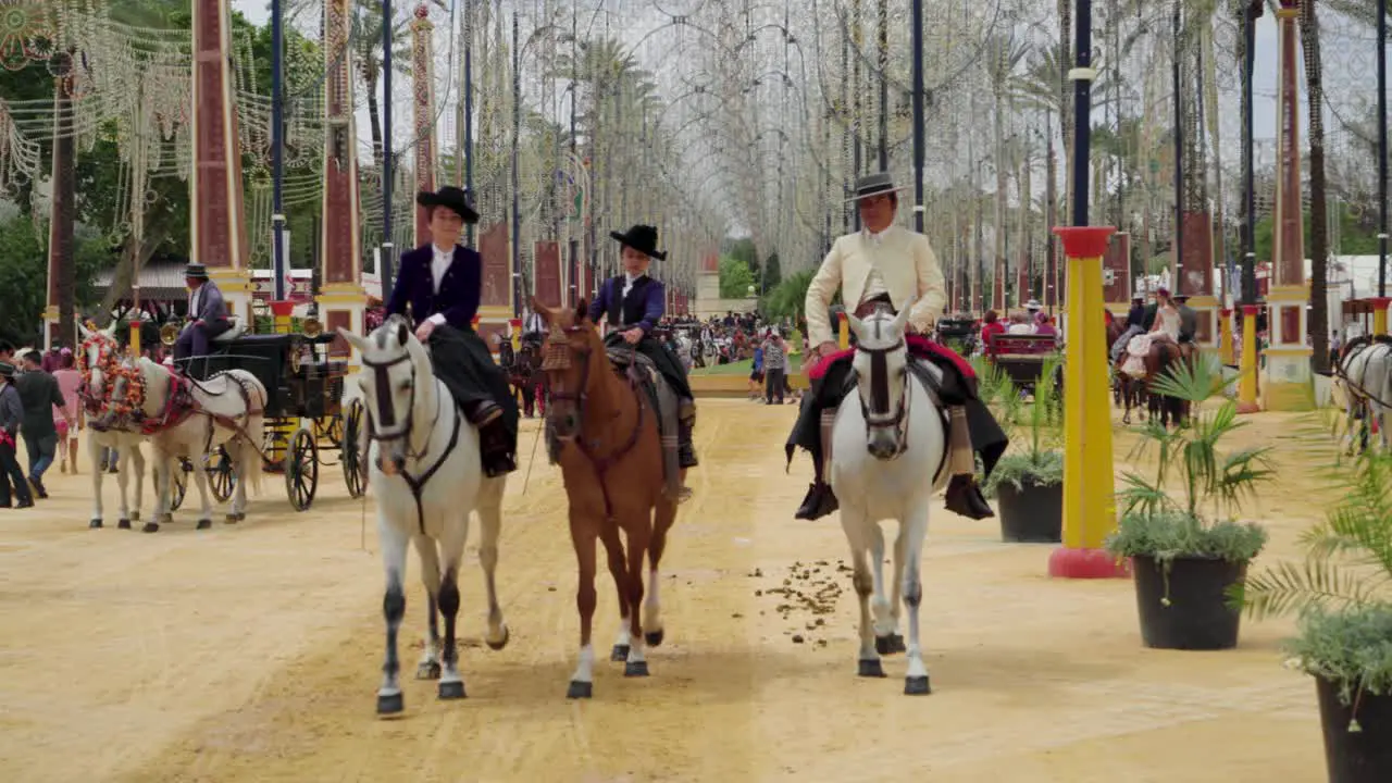 Three people riding horses at the Jerez Fair approach Spain