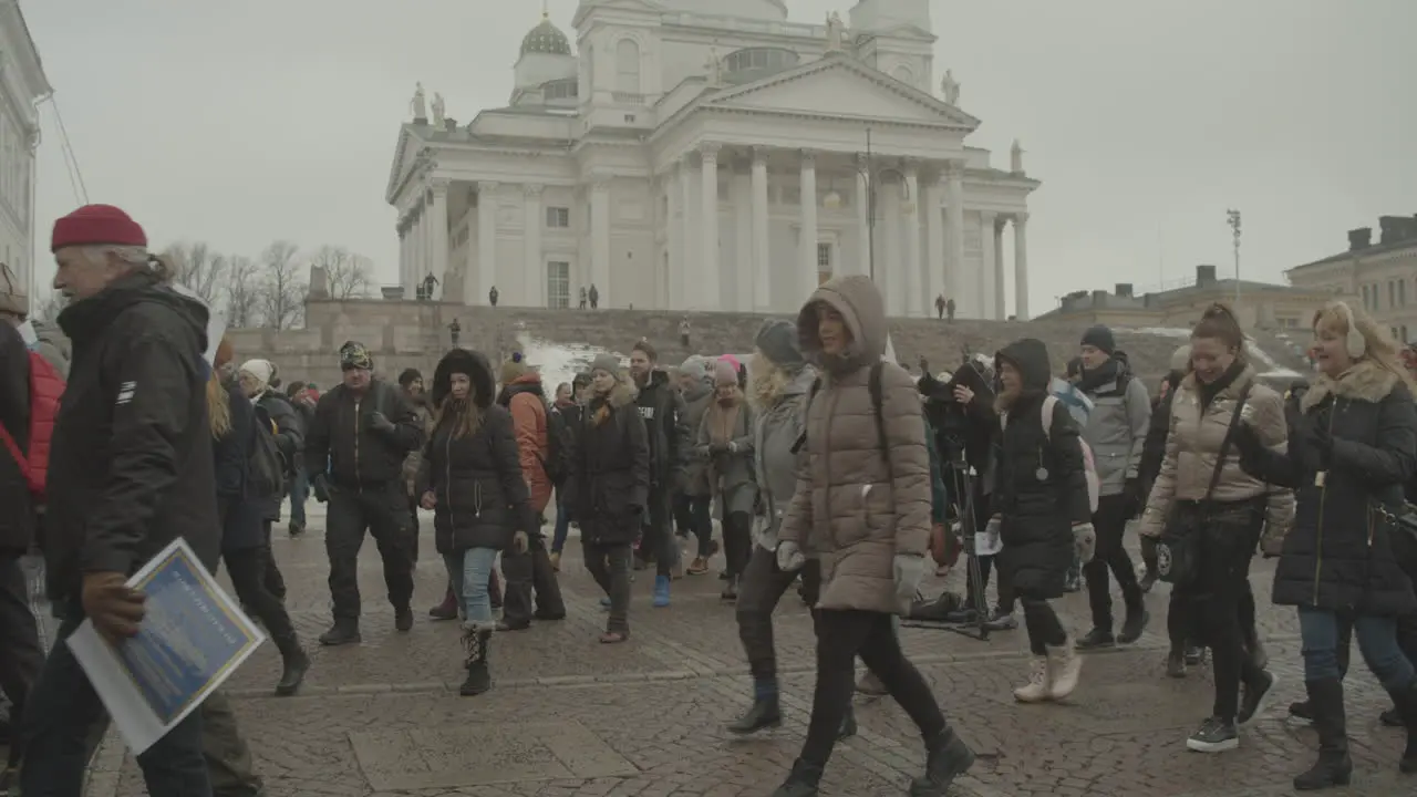 Huge crowd of protesters walk during a peaceful protest in from of Helsinki Cathedral on a cold winter day