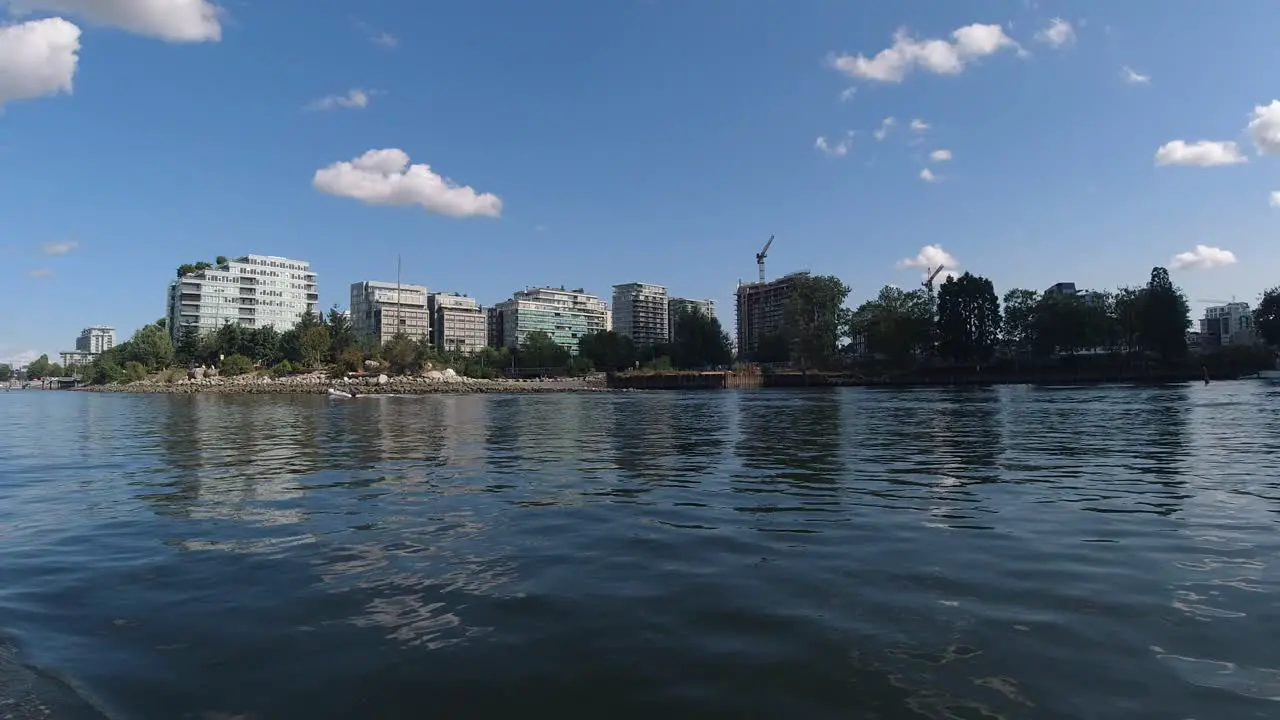 low aerial flyby False Creek downtown Vancouver Canada while motorboating people are enjoying the sunny hot day at the Olympic Village lowrise buildings harbor during the Labour Day holiday dingy3-7