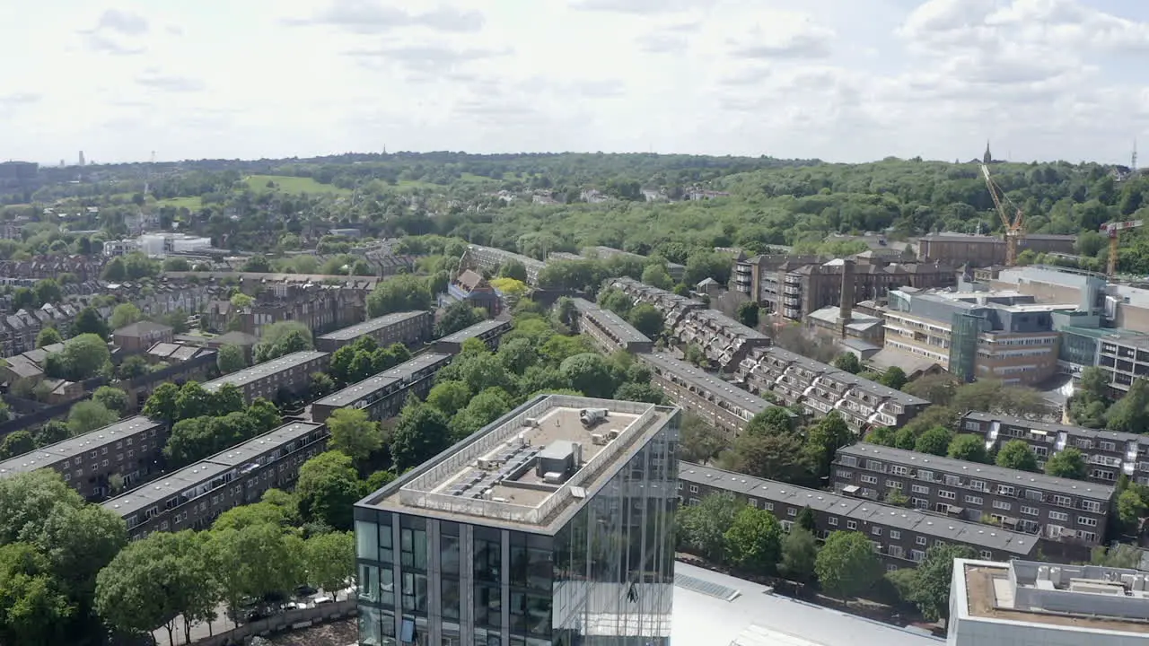 London aerial rises over building to reveal green Archway district