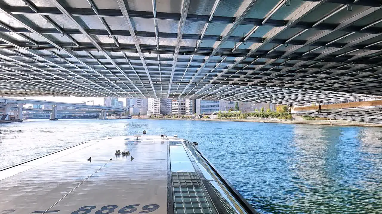 Beautiful transition passing under a very low bidge revealing blue sky city landscape in Tokyo Japan