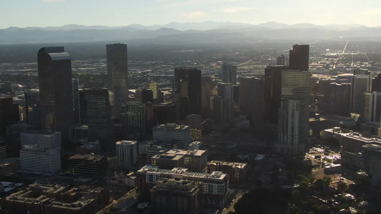 Aerial cinematic drone mid summer early fall Downtown Denver Colorado mile hight city buildings traffic wisp clouds blue sky afternoon sunset stunning golden hour light forwards pan up movement