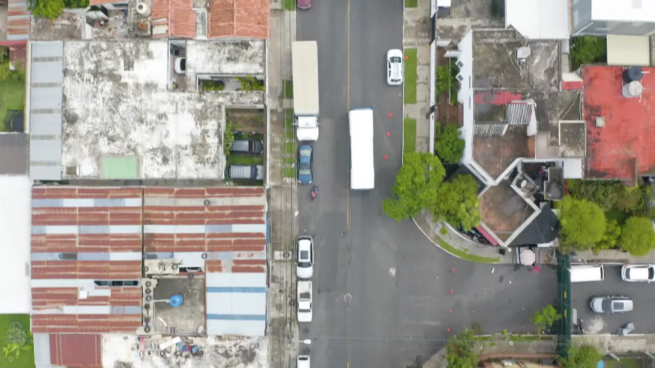 Drone capture the aerial view of the bus moving through the neighborhood of Guatemala City capital of Guatemala in Central America and passing by many vehicles