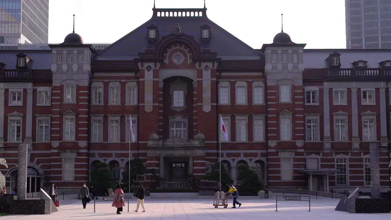 Tight frontal shot of Tokyo station with few people during early morning hours