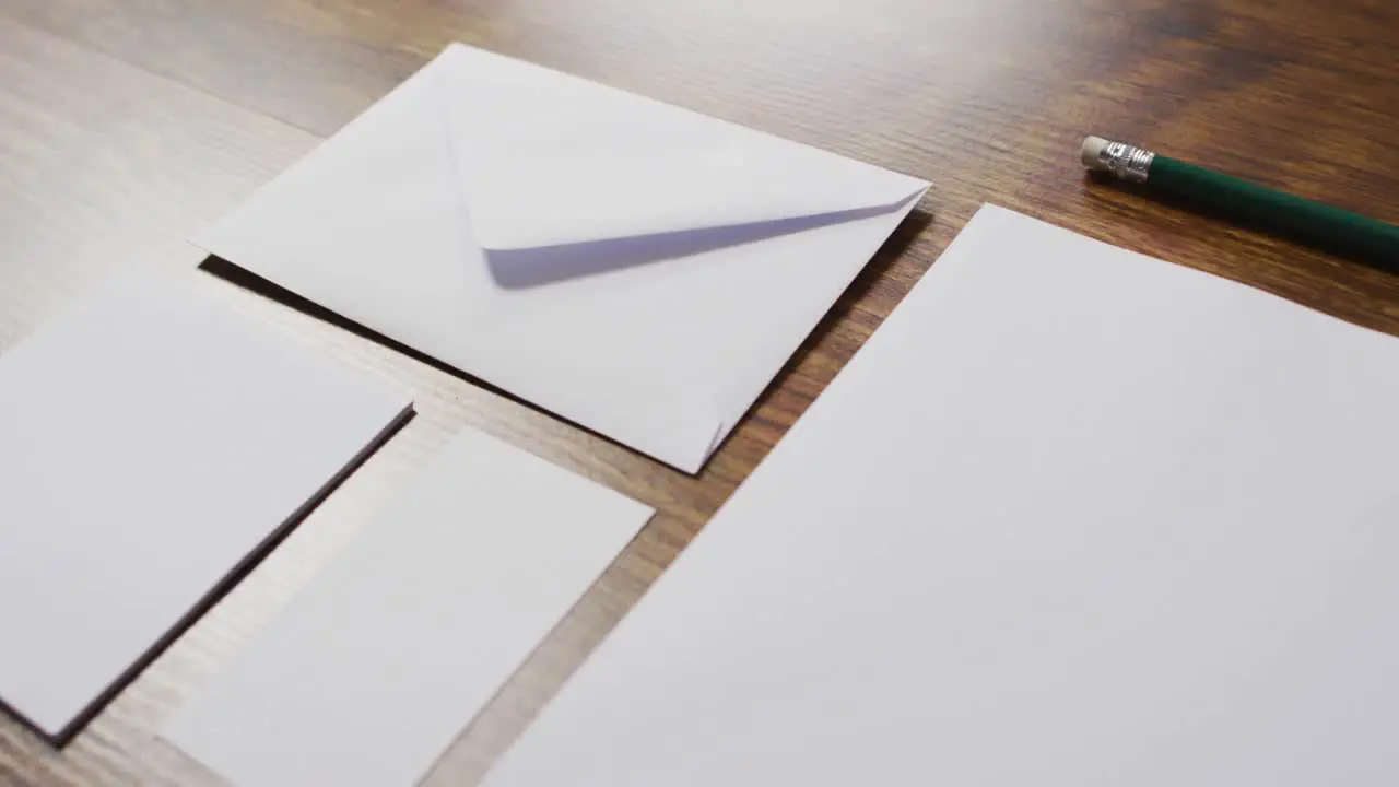 Video of envelope and white cards with copy space on wooden background