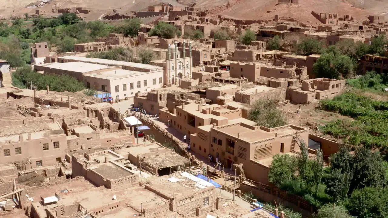 Overview of tourists walking around in Tuyoq city valley in Xinjiang Tuyuk aerial of oasis-village in the Taklamakan desert Flaming Mountains Xinjiang Uighur Region of China