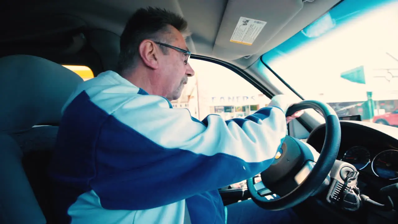 Older man driving in a parking lot