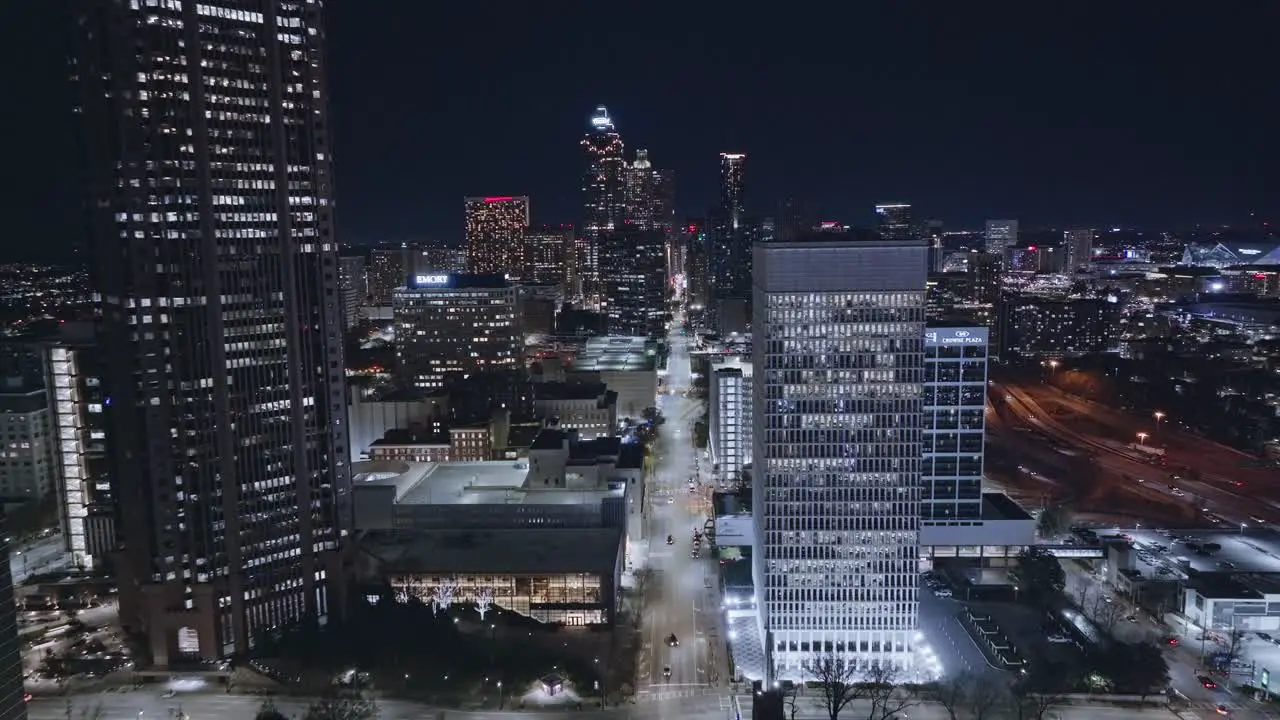 Aerial forward flight over illuminated city of Atlanta At night and traffic on main road in downtown