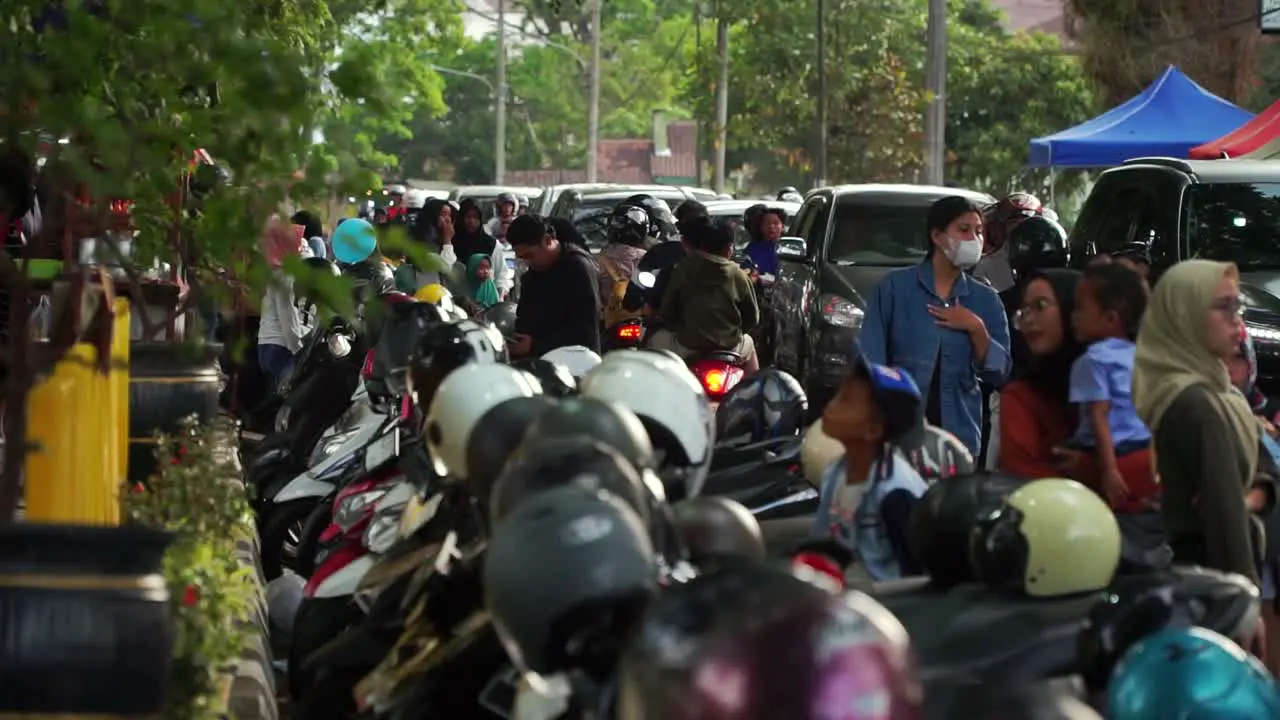 Crowded street of people and motorbikes in Indonesia handheld view