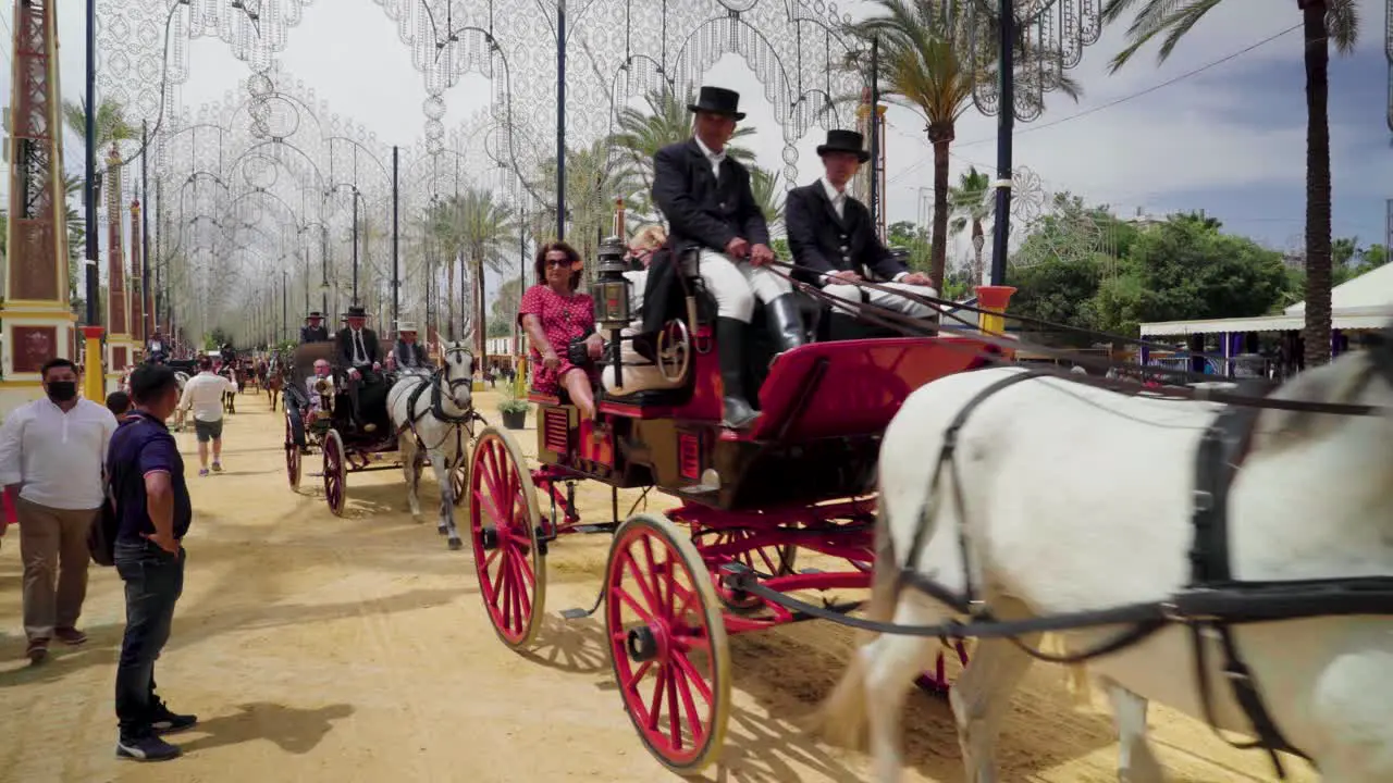 Horses pull carriages of people enjoying the fair in Jerez de la Frontera Spain