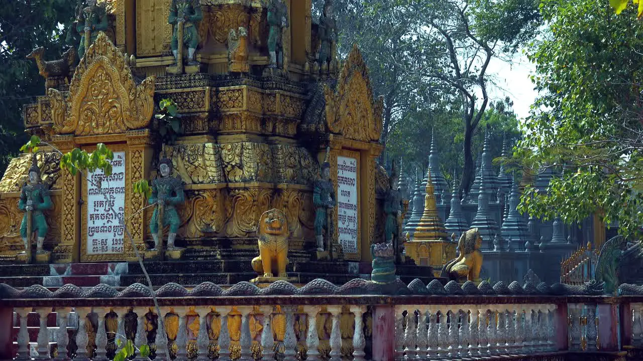 Medium Shot of Pagoda Shrines With Tree Blowing